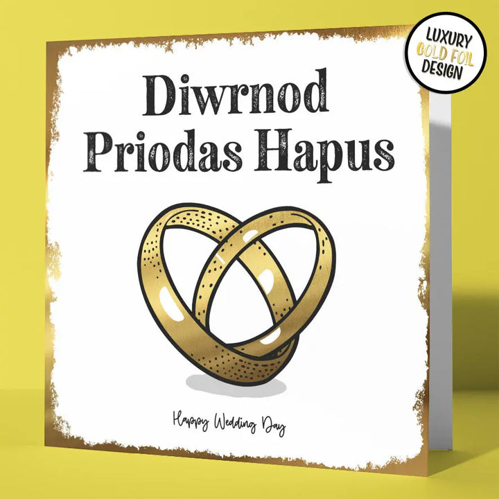 Bilingual Welsh wedding card with gold foil interlocking rings and 'Diwrnod Priodas Hapus' text at the top and 'Happy Wedding Day' text at the bottom.