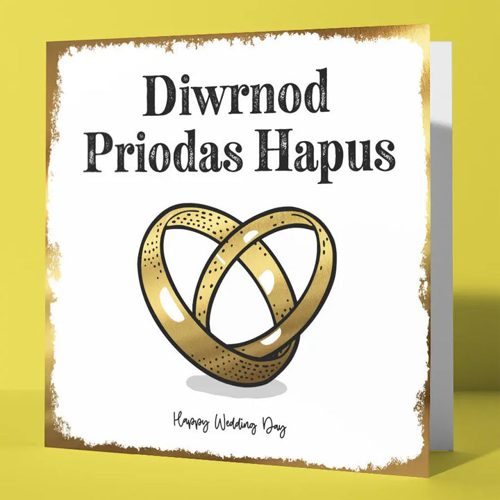 Bilingual Welsh wedding card with gold foil interlocking rings and 'Diwrnod Priodas Hapus' text at the top and 'Happy Wedding Day' text at the bottom.