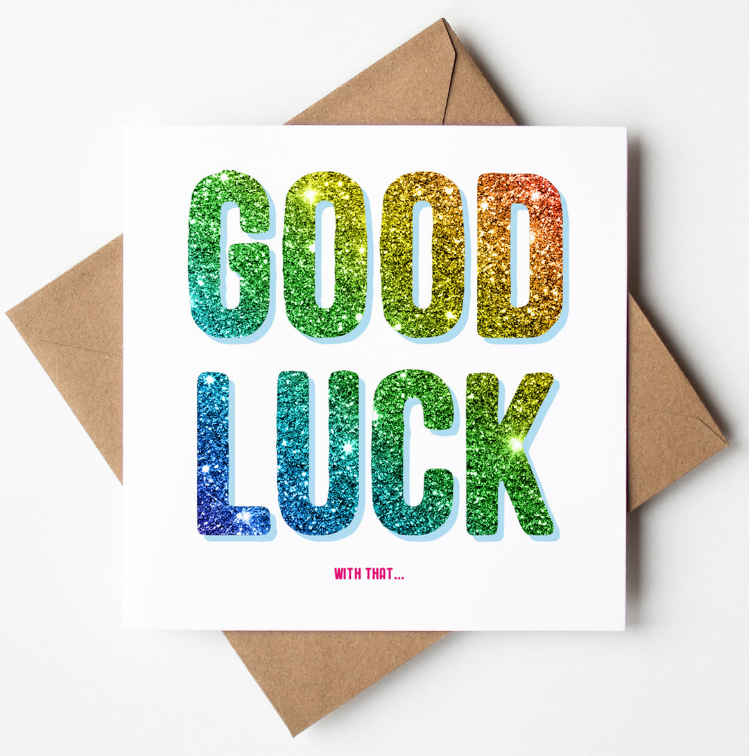 A perfect funny retirement card, the "Good Luck With That Card" features "GOOD LUCK" in large, colorful glitter letters on a white backdrop, followed by the humorous phrase "WITH THAT..." in smaller pink text. The card is complemented by a neatly paired brown envelope.