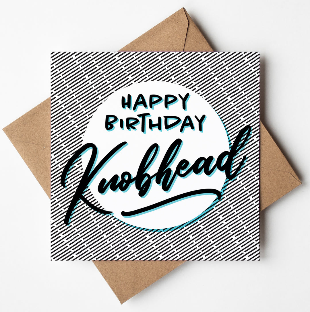 The Happy Birthday Knobhead Card, crafted in Wales, showcases a square design with a black and white herringbone pattern. It features bold and stylish text that reads "Happy Birthday Knobhead," ideal for those who appreciate cheeky humor. It is accompanied by a brown envelope.