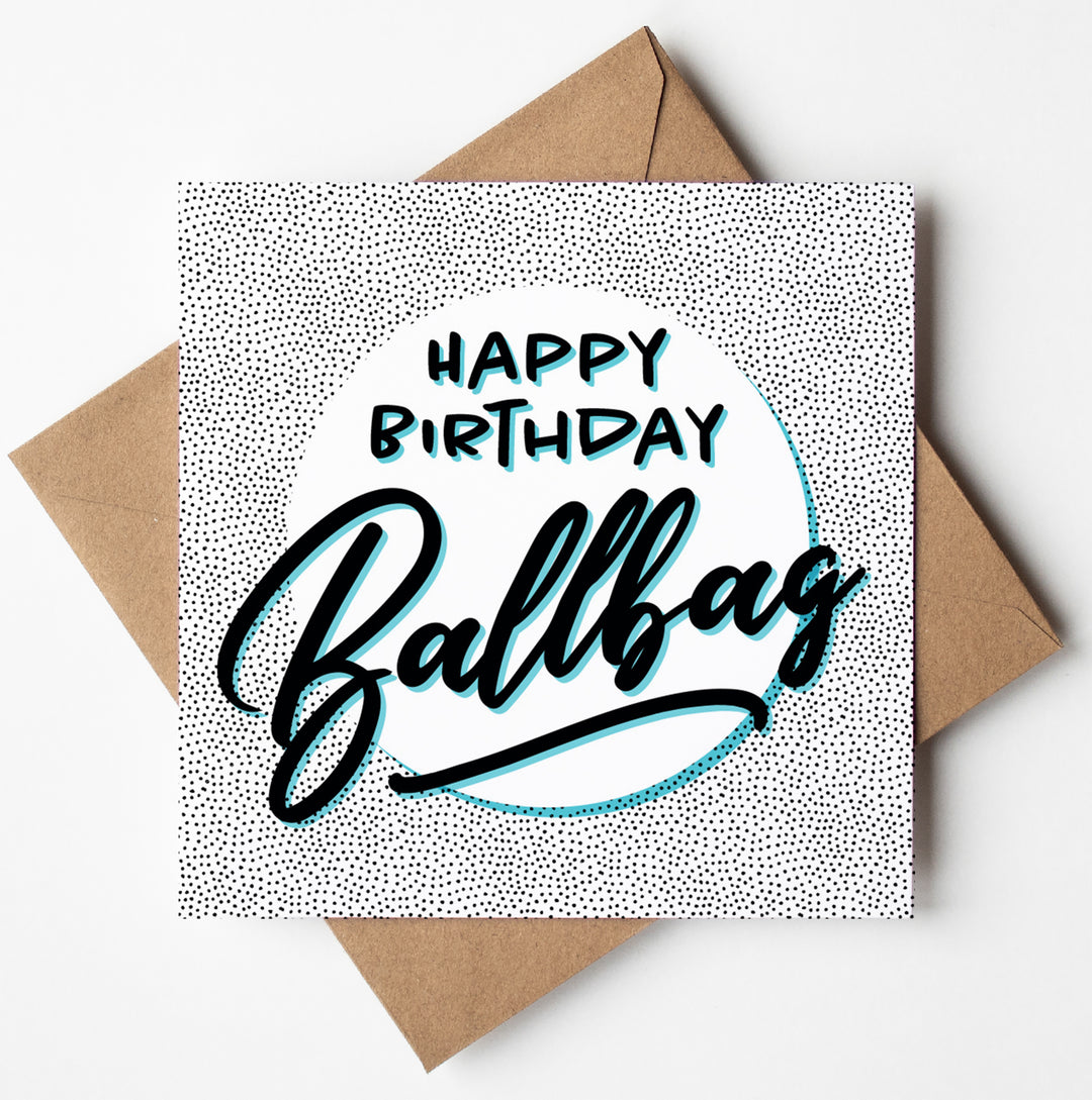 The Happy Birthday Ballbag Card showcases a humorous polka dot design with bold, stylized "Happy Birthday Ballbag" text in black and blue on a light background. Ideal for those who enjoy an edgy sense of humor, this card comes with its own brown envelope.