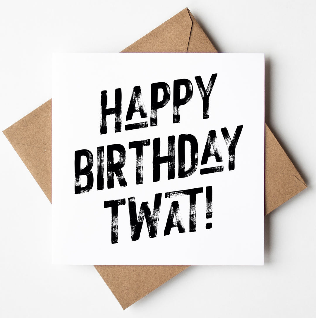 The Happy Birthday Twat! Harlem Card, featuring a square design with bold black text reading "HAPPY BIRTHDAY TWAT!" rests on a brown envelope against a white background, making it perfect for special day celebrations.