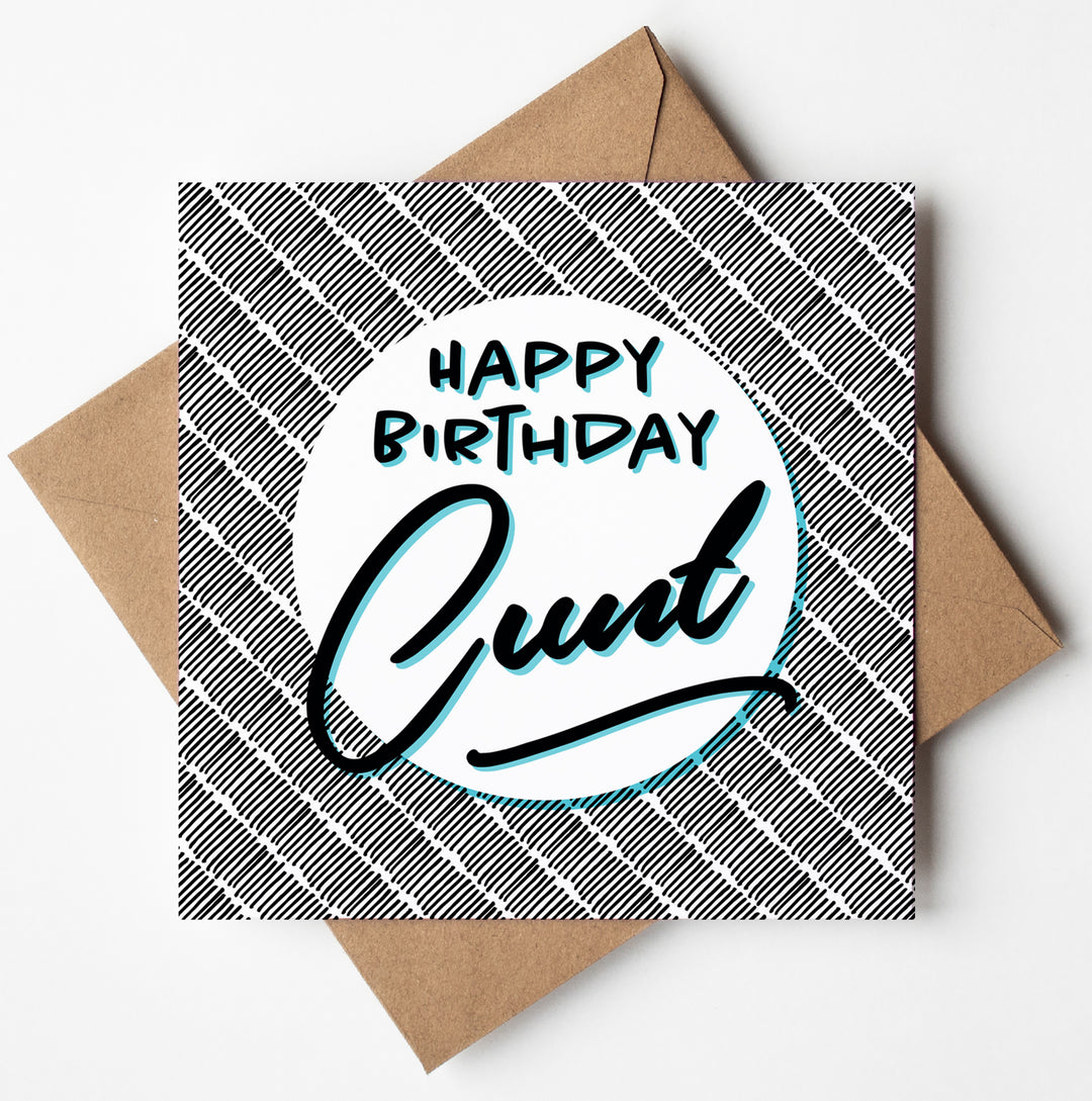 A birthday card featuring a checkered pattern background with the playful message "Happy Birthday Cunt!" in bold black and blue letters. The card is paired with a brown envelope and prepared for global shipping in an environmentally friendly biodegradable bag.