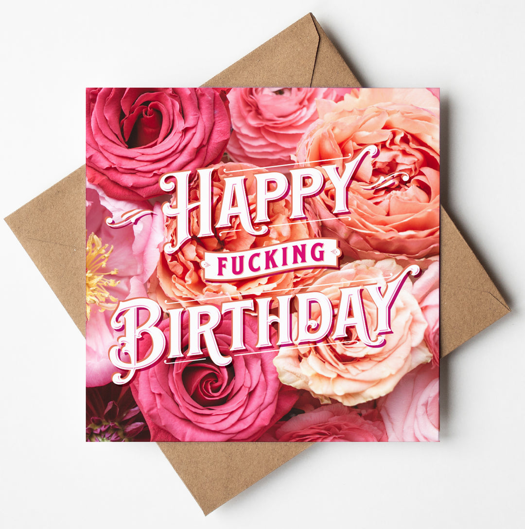 A card named "Happy Fucking Birthday Ranunculus" showcases striking pink and peach ranunculus flowers in the background, with bold white and pink text declaring "Happy Fucking Birthday." It's tastefully accompanied by a simple brown envelope.