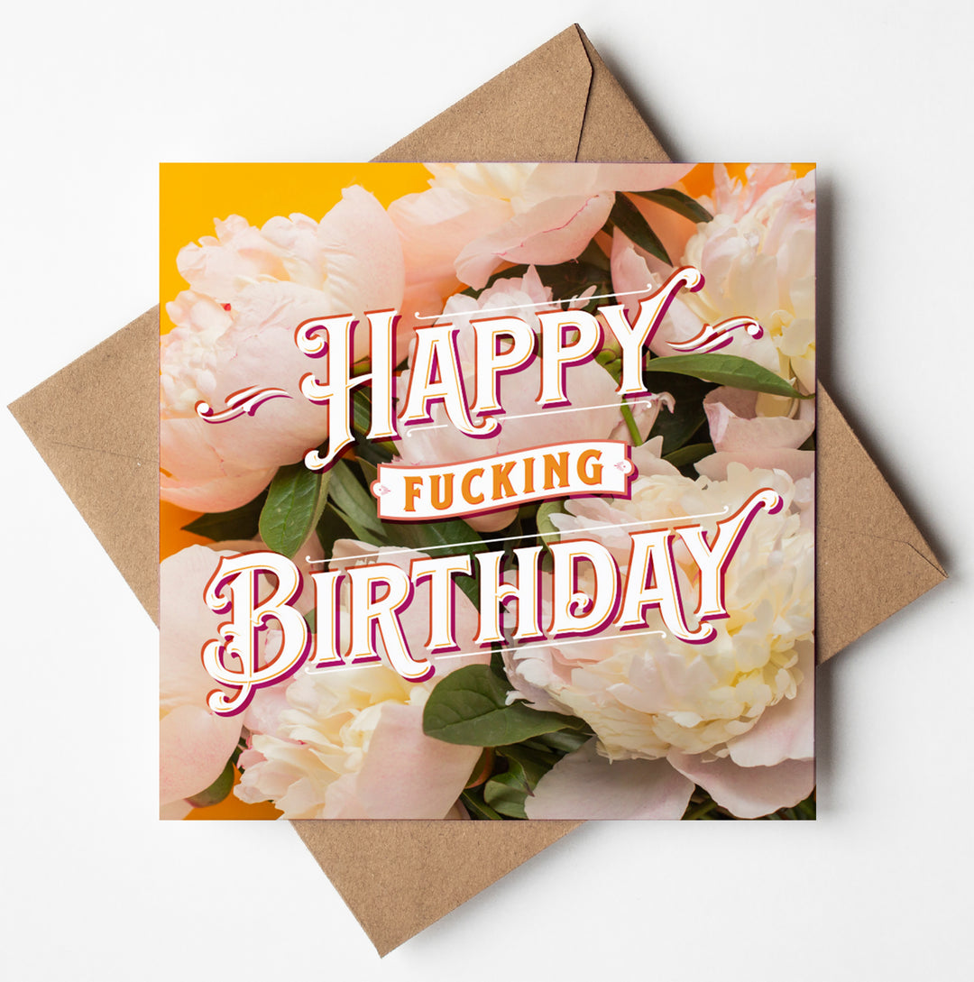 The Happy Fucking Birthday Cream Peonies Card showcases bold text that reads "Happy Fucking Birthday" against a backdrop of cream peonies. The square card is elegantly displayed on a brown envelope, effortlessly combining edgy flair with floral elegance.