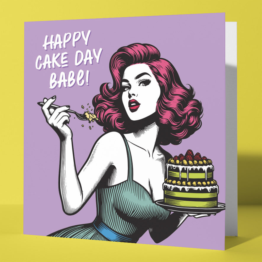 The Happy Cake Day Babe! Vintage Babes Birthday Card features a pop art-style woman with red hair holding a fork and layered cake on a purple background, with white text: “Happy Cake Day Babe!”—a fun birthday card for your bestie.