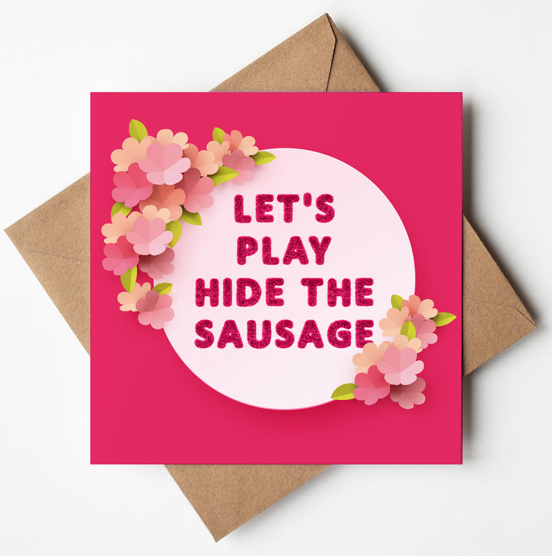 A "Let's Play Hide The Sausage" Valentine's card features pink and red flowers on the side and is accompanied by a brown envelope.