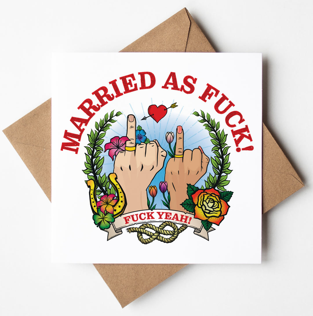 The Married As Fuck Tattoo Wedding Card (M/F) features a bold declaration of "Married As Fuck!" and "Fuck Yeah!", with two hands wearing wedding rings and raising their middle fingers. The background is beautifully adorned with flowers, leaves, a heart, and intertwined rings—perfect for those who appreciate some cheeky humor in their wedding cards!