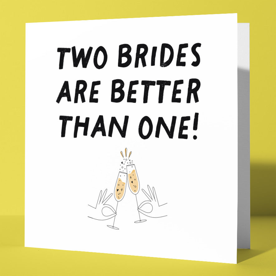 The "Two Brides Are Better Than One! Gay LGBTQ Wedding Card" shows two hands clinking champagne glasses beneath the joyful text and is set against a bright yellow background.