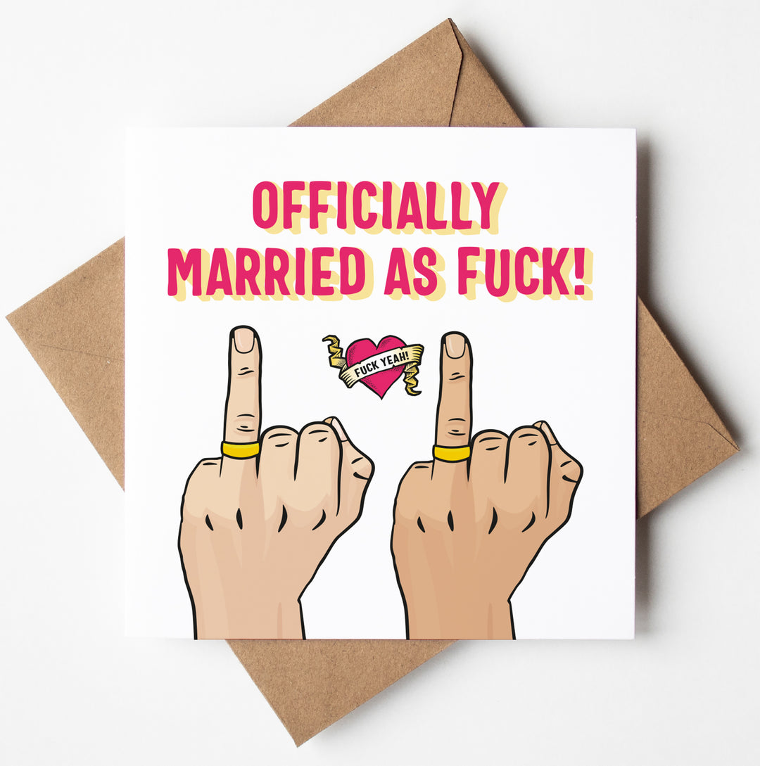 The "Officially Married As Fuck Card (M/M)" humorously depicts two hands with wedding rings flipping the middle finger. A heart between them shouts "Fuck Yeah!" and bold letters declare, "OFFICIALLY MARRIED AS FUCK!" Beneath this cheeky wedding card is a brown envelope.