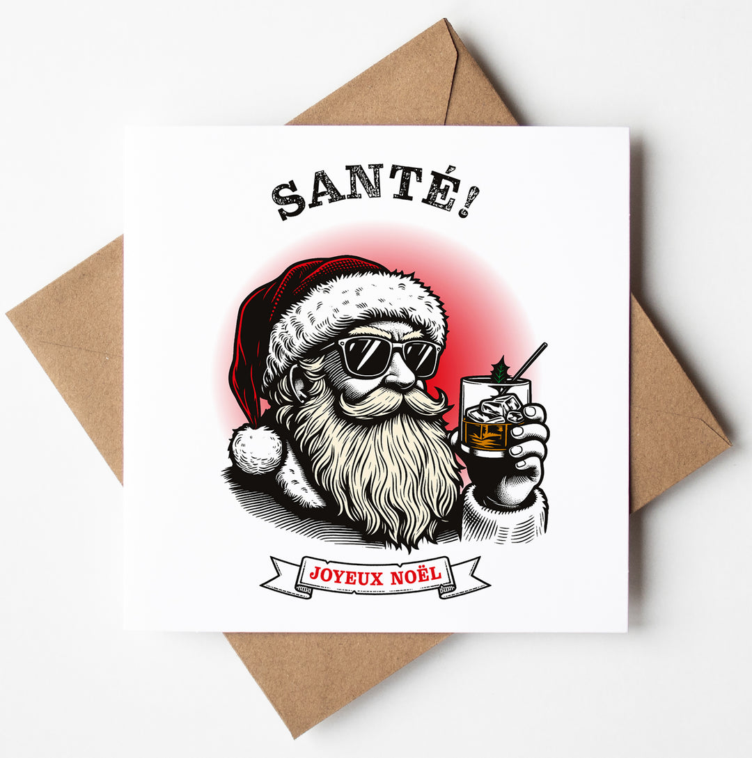 The "Santé! Joyeux Noel" French Gallic Christmas Card features a trendy Santa Claus sporting sunglasses and holding a glass of whiskey, set against a red glow. The card displays "SANTÉ!" at the top and "JOYEUX NOËL" on a banner below. It comes with a brown envelope and is available for worldwide shipping to spread your holiday cheer.