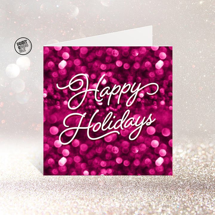 The SALE! Happy Holidays Gorgeous Christmas Card features a sparkling pink and magenta bokeh background with “Happy Holidays” in elegant white script. UK printed, it stands on a glittery surface and comes in a biodegradable bag.
