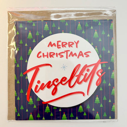 The SALE! Merry Christmas Tinseltits Trees Navy Card is UK printed, features a tree pattern and "Merry Christmas Tinseltits" in bold red on a white circle, and comes in a clear biodegradable bag.