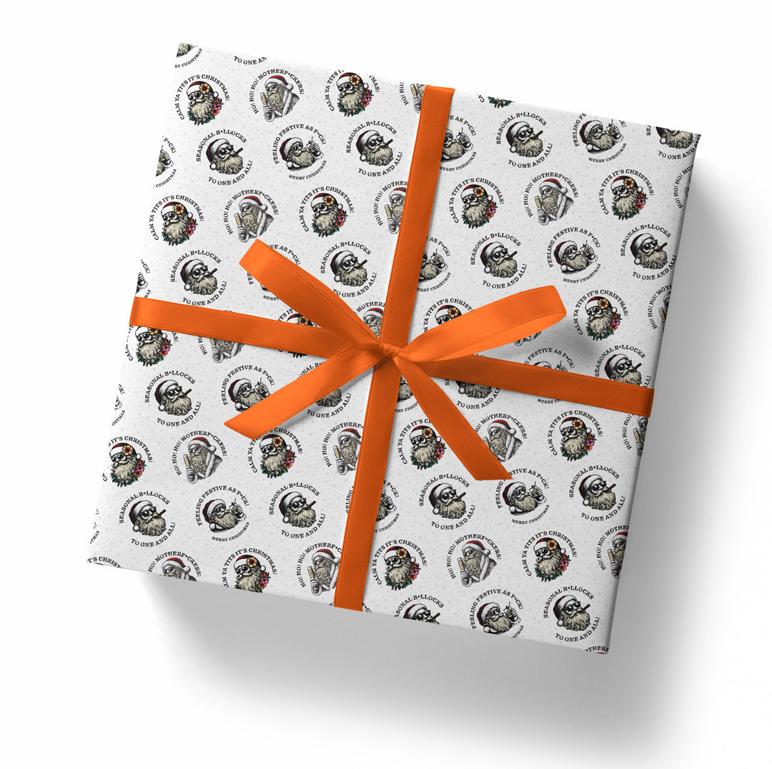Gift box wrapped in paper with a sunglass wearing santa pattern and an orange ribbon on a white background