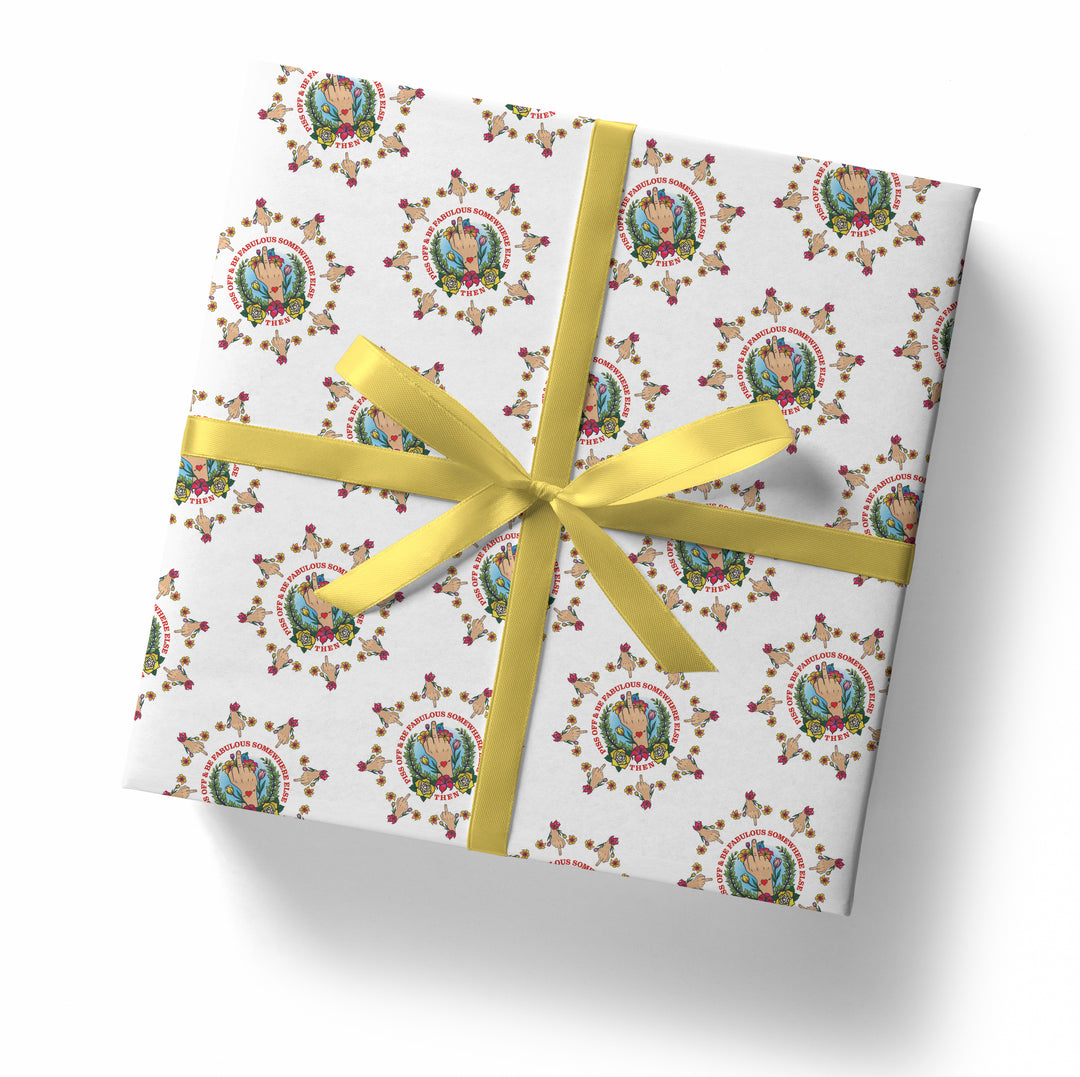 A square gift box wrapped in the SALE! Middle Finger Piss Off Tattoo Gift Wrap (Folded Sheet), featuring a colorful floral pattern and illustrated figure, tied with a yellow satin ribbon and bow, set against a plain white background.