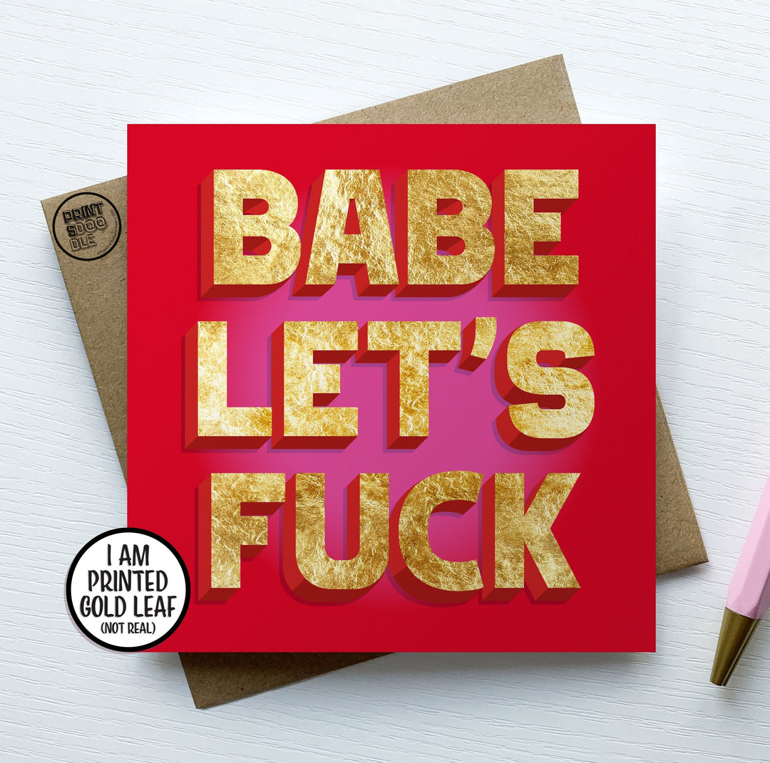 A square greetings card with a red and pink background with the words "BABE LET'S FUCK" in a printed gold, embossed letters.