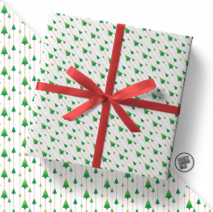 A Christmas gift wrapped in "Modern Christmas Tree Gift Wrap (Folded Sheet)" features white paper adorned with a green Christmas tree pattern and is tied with a red ribbon bow, set against a backdrop displaying the same festive wrapping paper.