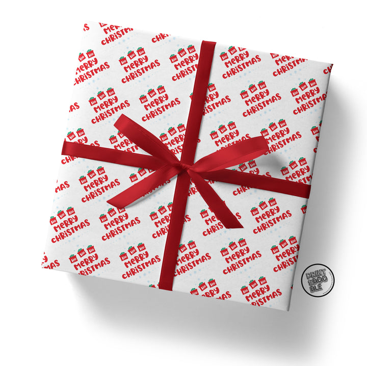 The Ho Ho Ho Christmas Gift Wrap (Folded Sheet) features a charming square gift box layered in festive white paper embellished with red "Merry Christmas" text and decorative icons. It is beautifully finished with a red ribbon and bow, making it ideal for Secret Santa. The package includes a small round tag on the side and is ready for worldwide shipping.